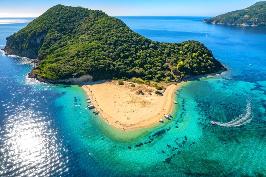 Marathonisi island in Zakynthos with green slopes and bright shoreline